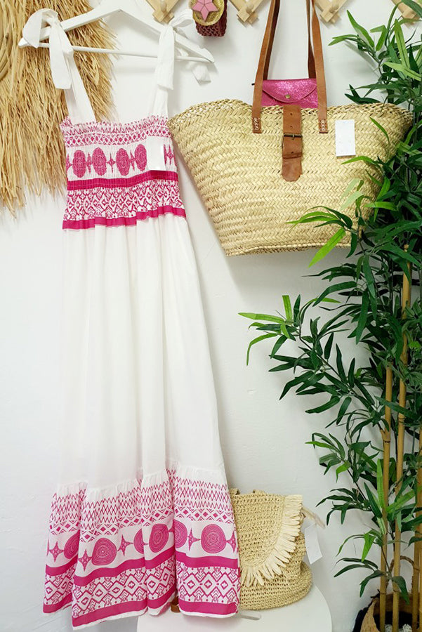 Woman wearing the Teresa™ boho print maxi dress with a gathered bodice, enjoying a warm summer day outdoors.