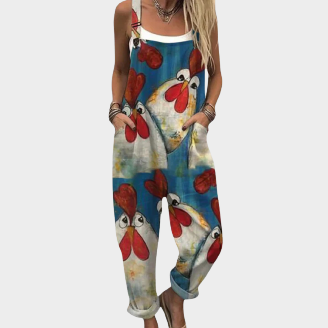 Woman wearing rich blue dungarees printed with big cheerful hens with bright red combs