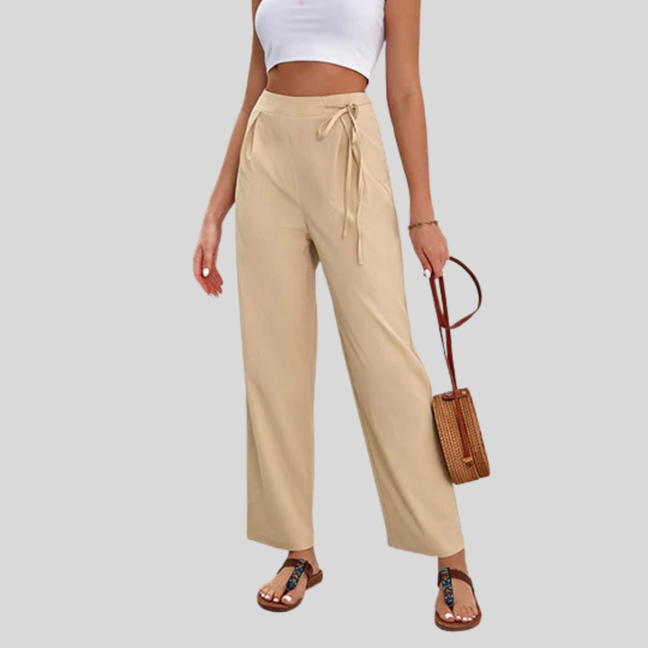 Woman wearing high-waisted wide-leg trousers with a knot detail and a tucked-in top.