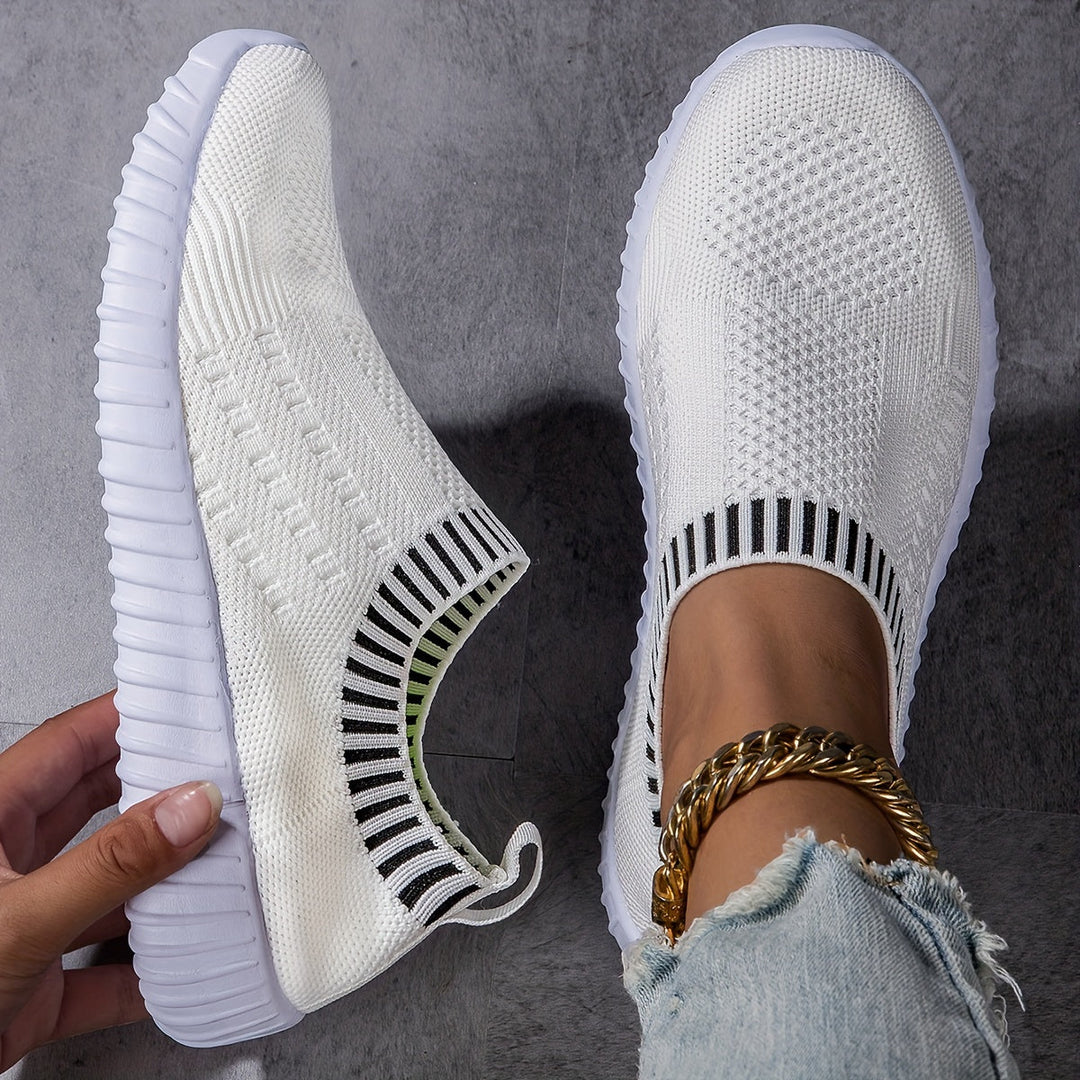 A woman slipping on ultralight sock-style trainers that hug the foot.