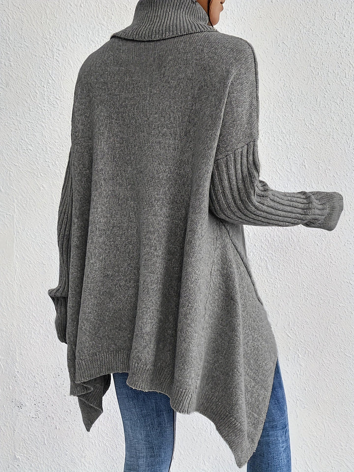 A woman wearing a stand-collar jumper with a chic asymmetric drape, warm and polished.