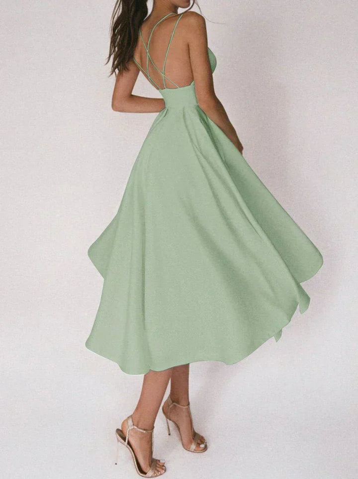 Woman at a summer celebration wearing the Katie minimalist maxi dress with fine double straps and a floating skirt.