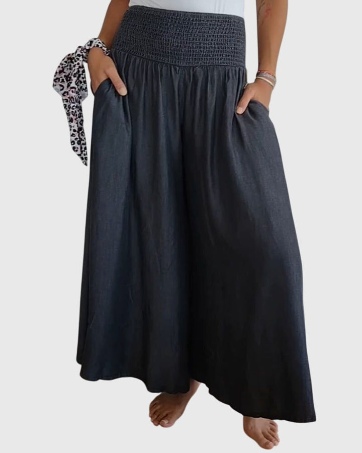 A woman in wide-leg trousers with a high elastic waist, styled for a relaxed boho look.