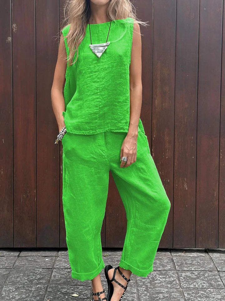A woman wearing a relaxed sleeveless top with ankle-length trousers, easy and elegant.