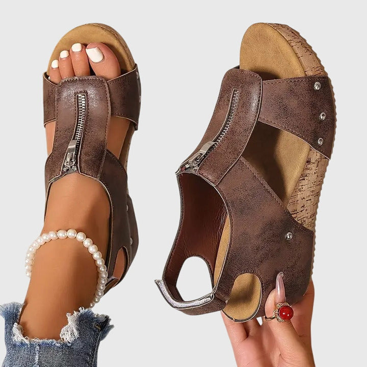 A woman standing at ease in wide-fit supportive comfort sandals with adjustable straps.