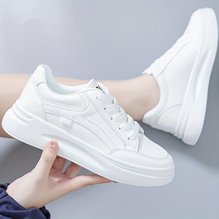 A woman in crisp white light comfort trainers paired with jeans.