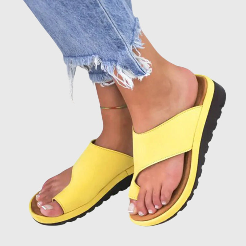 A woman in gold supportive sandals standing gracefully, feet cushioned and at ease.