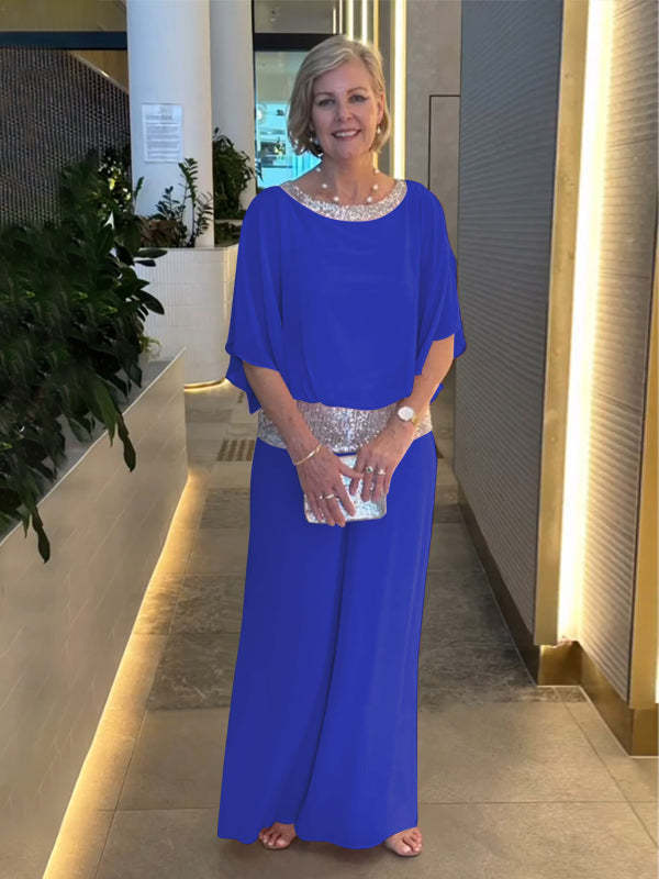 A woman wearing an embellished blouse-style top with softly flowing wide evening trousers.