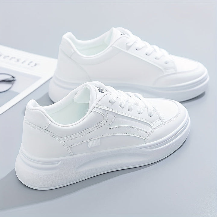 A woman in crisp white light comfort trainers paired with jeans.