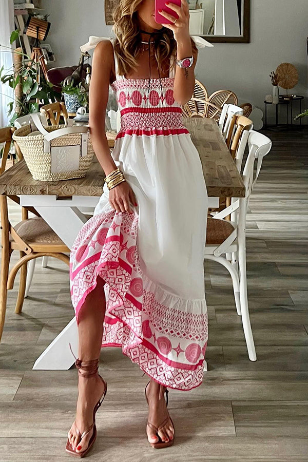 Woman wearing the Teresa™ boho print maxi dress with a gathered bodice, enjoying a warm summer day outdoors.