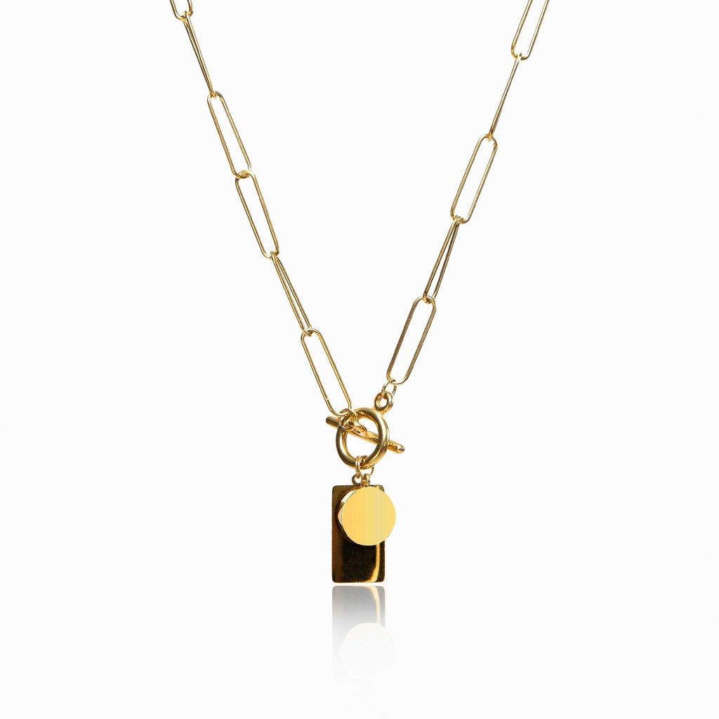 Gold chain necklace with a sleek rectangular clasp on a plain background