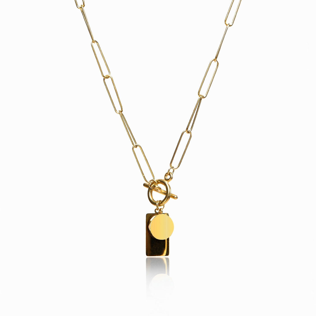 Gold chain necklace with a sleek rectangular clasp on a plain background