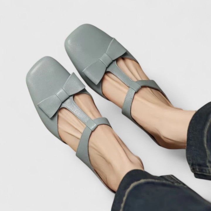 A woman wearing soft pink comfort sandals with a broad, cushioned footbed on a sunny day.