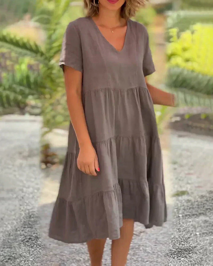 Woman wearing the Veronica™ V-neck summer dress with a soft layered skirt, strolling on a sunny afternoon.