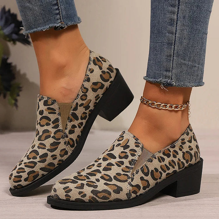 A woman wearing leopard-print loafers with jeans, stepping out with easy confidence.