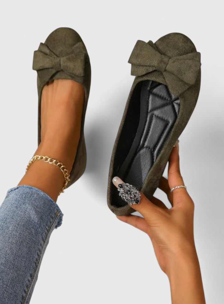 A woman walking easily in dark green classic comfort sandals with a broad, cushioned footbed.