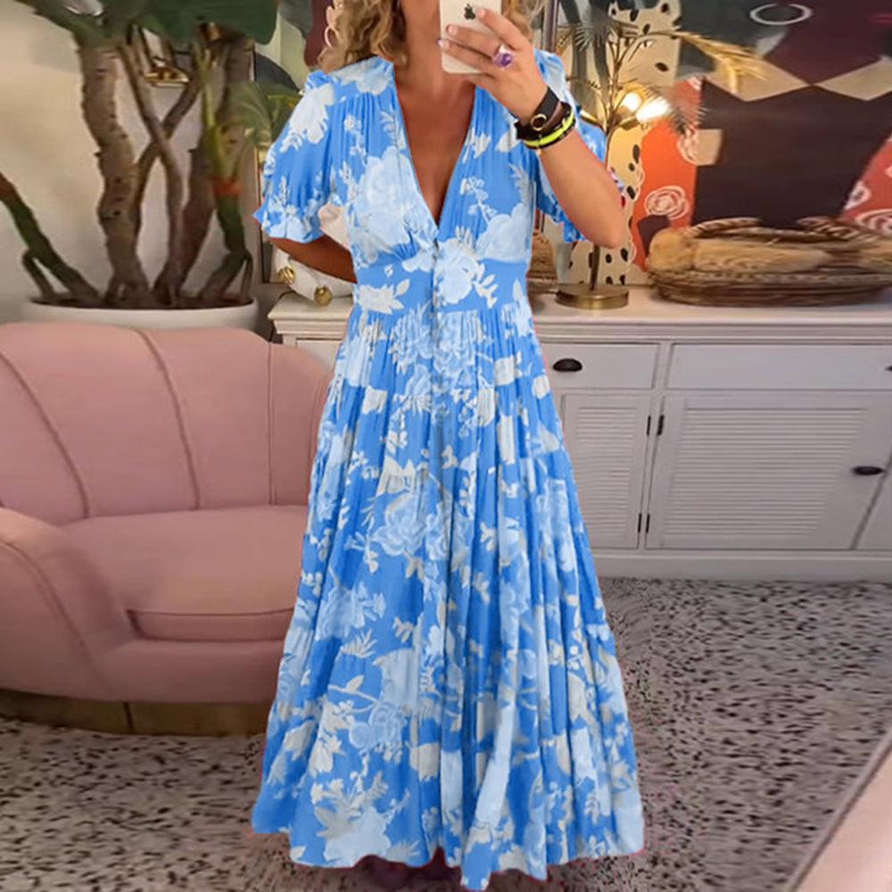 A woman wearing the Josephine bold floral maxi dress with a flowing full-length skirt at a garden gathering.