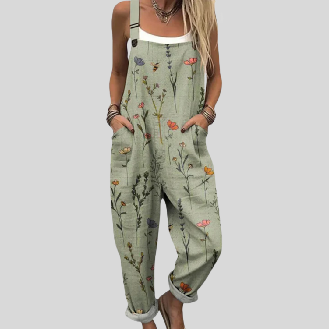 Woman wearing the Niamh™ sage green wide-leg dungarees covered in a delicate colourful wildflower print.