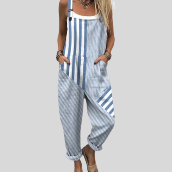 A woman wearing fresh blue-and-white striped dungarees on a seaside walk.
