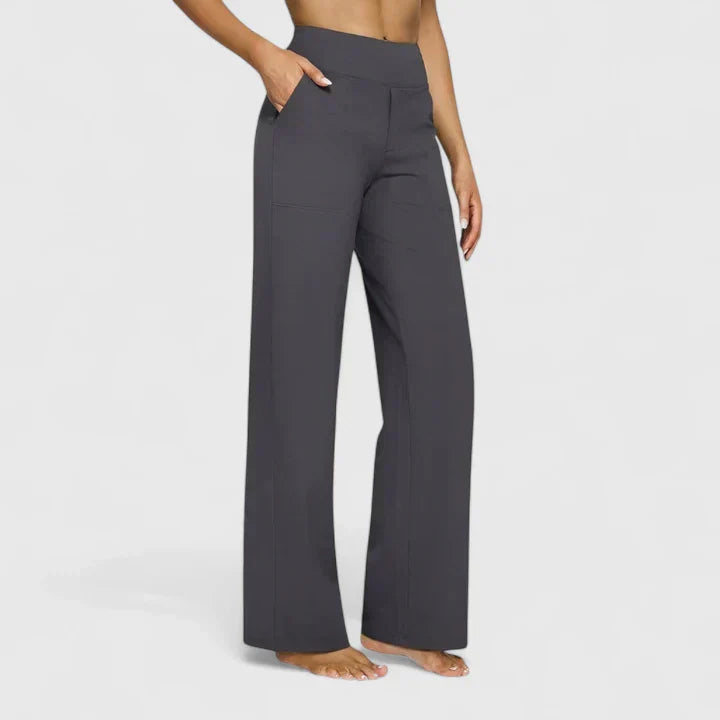 A woman in tailored trousers styled with a simple top for an elegant, comfortable everyday look.