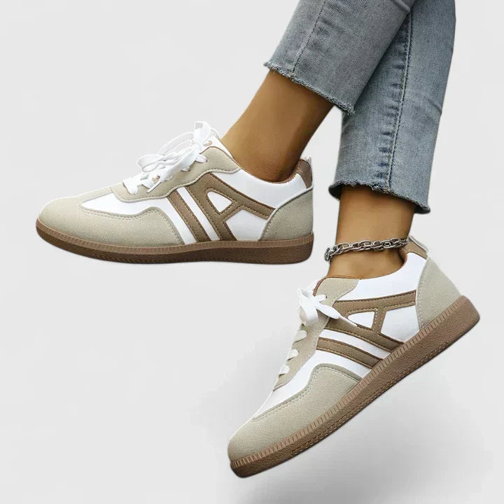 A woman wearing khaki and white orthopaedic trainers on a relaxed walk.