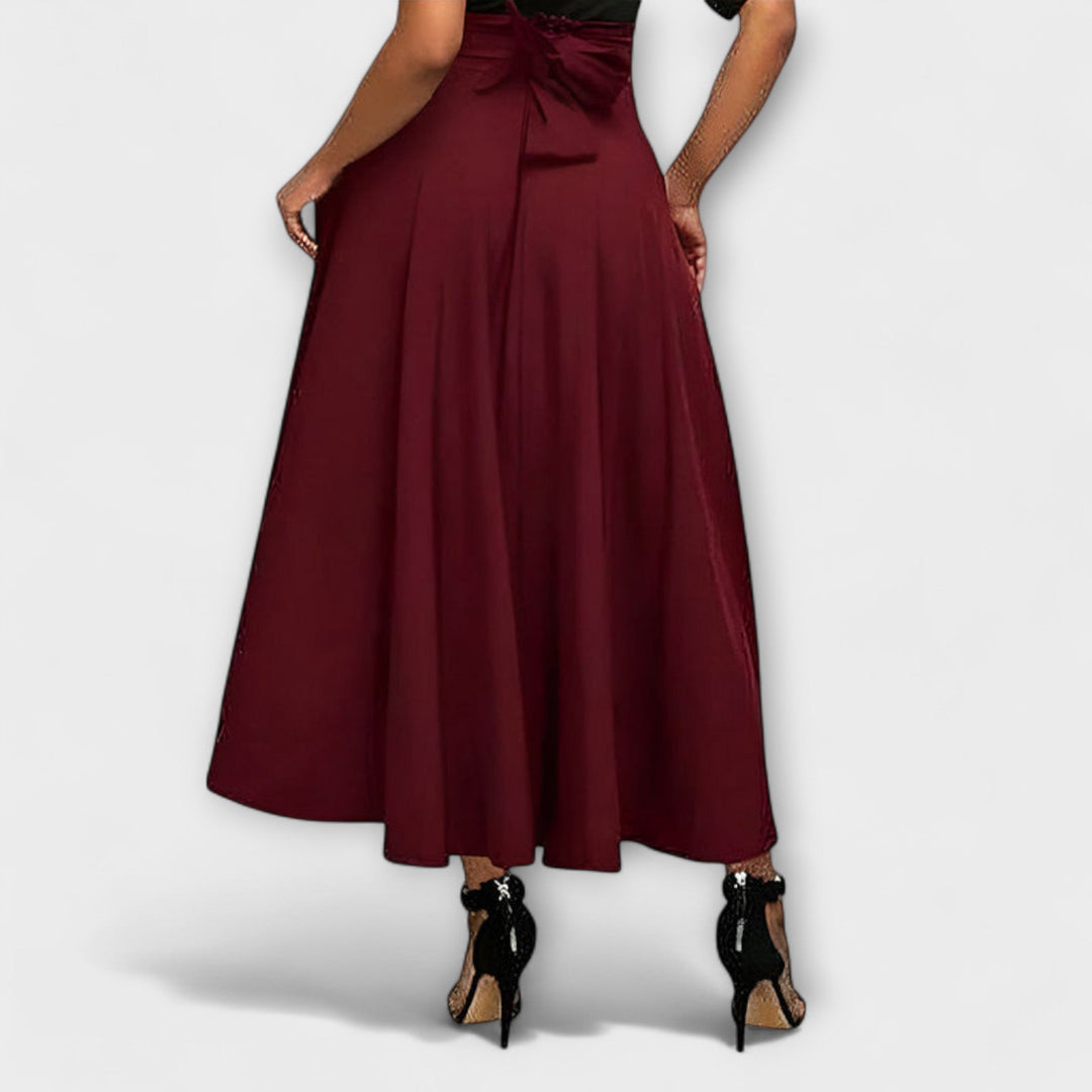 A woman in a flowing elegant maxi skirt styled with a simple top for a confident, striking look.