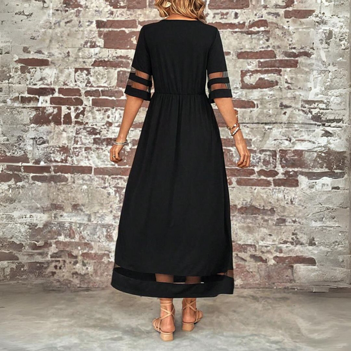 Woman wearing the Winifred™ empire waist midi dress with a flowing skirt and round neckline at a family gathering.