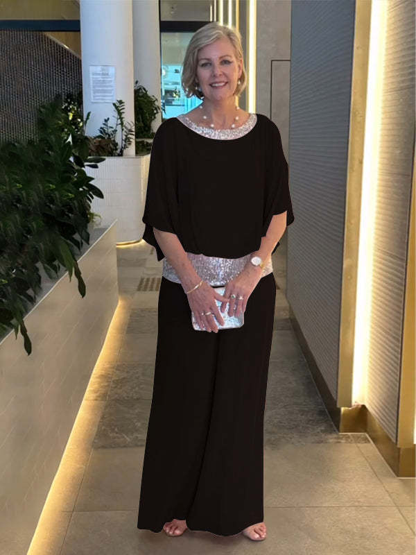 A woman wearing an embellished blouse-style top with softly flowing wide evening trousers.