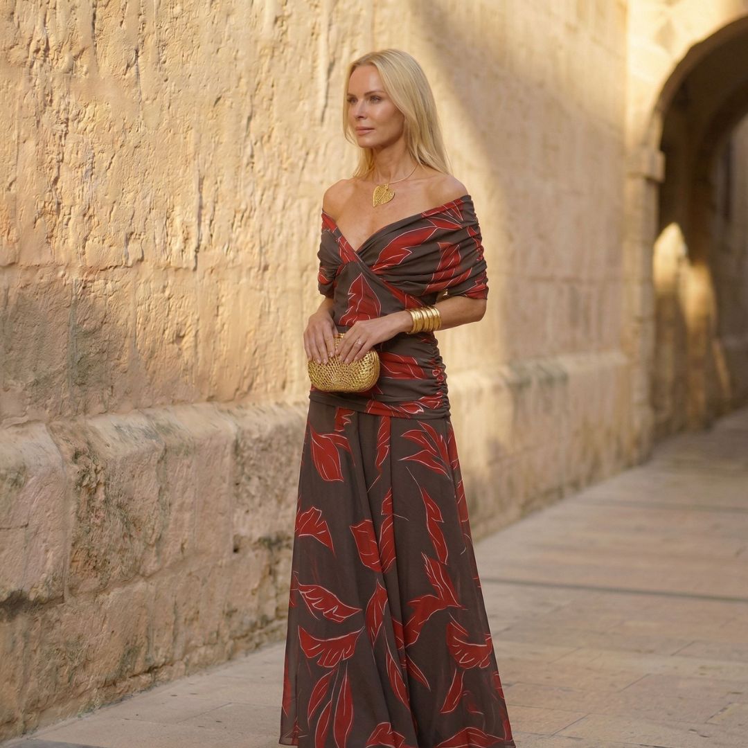 A woman wearing a flowing red dress with a soft leaf print at an occasion.