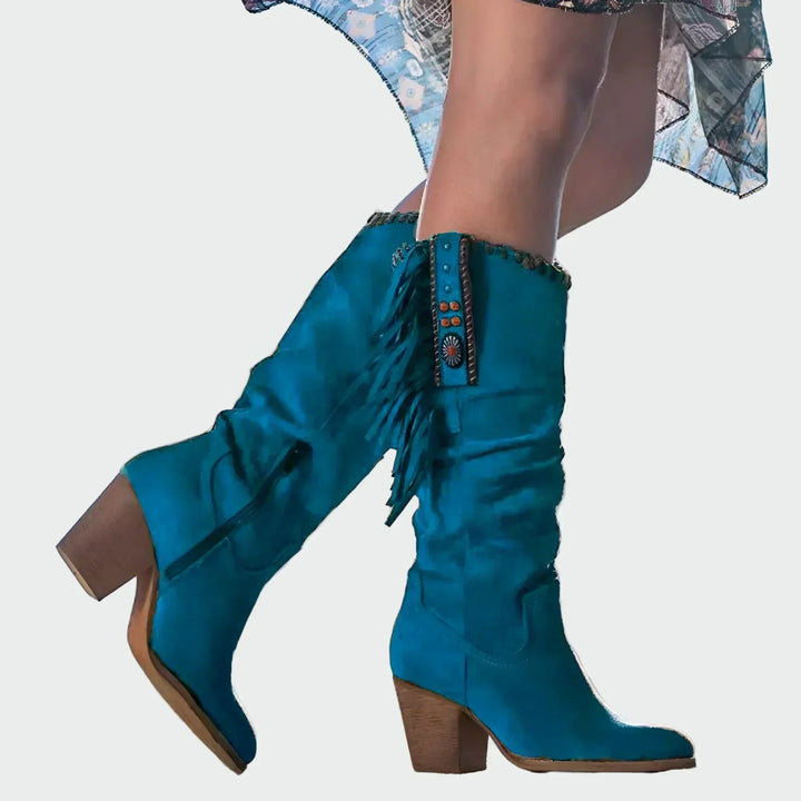 Woman wearing fringed boho-Western ankle boots with a floaty dress at a festival.