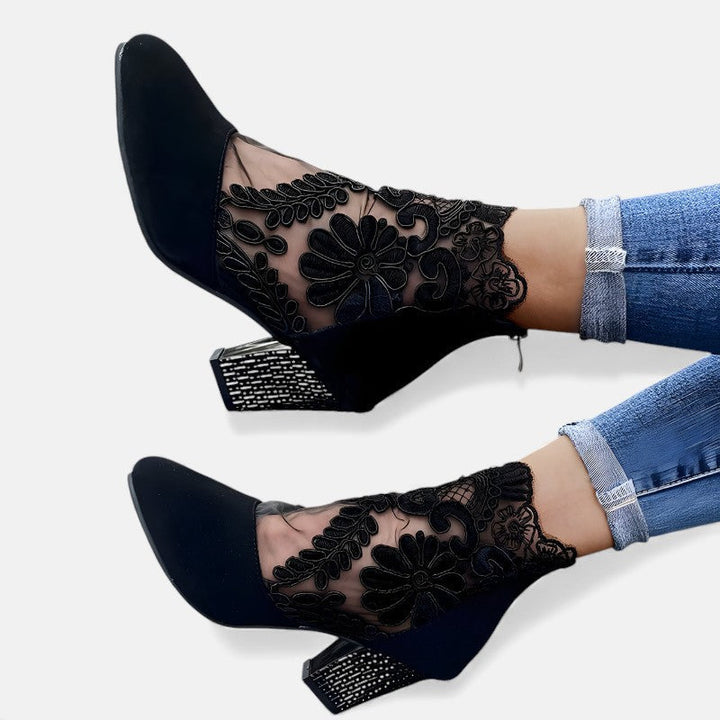 A woman wearing wide-toe orthopaedic heels, standing comfortably in an elegant everyday look.