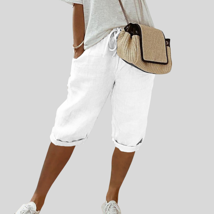 A woman wearing elegant flowing shorts with a soft elastic waist and deep pockets.