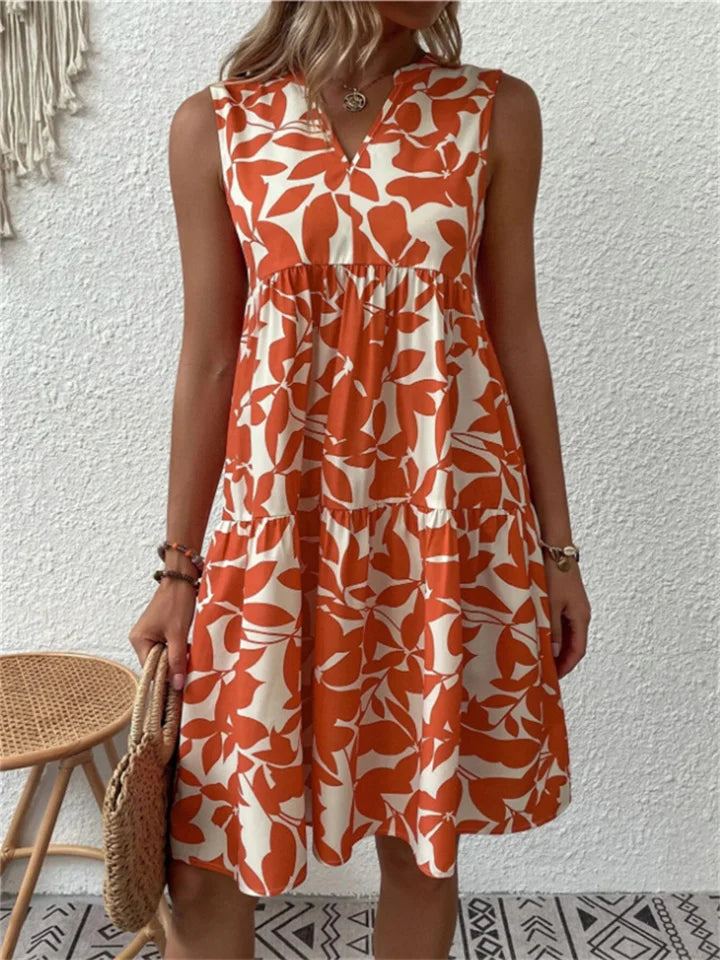 Woman wearing the Eileen sleeveless floral midi dress, relaxing outdoors on a warm afternoon.