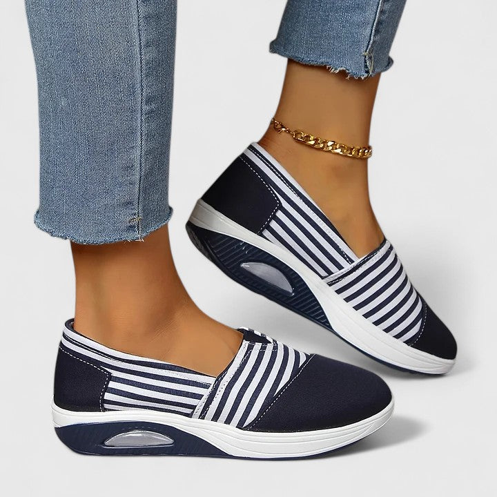A woman wearing blue striped orthopaedic trainers on a walk