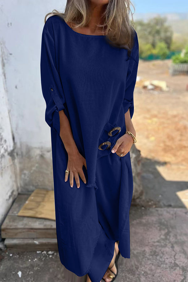 A woman wearing a flowing draped two-piece set with an asymmetric hem, relaxed and elegant.