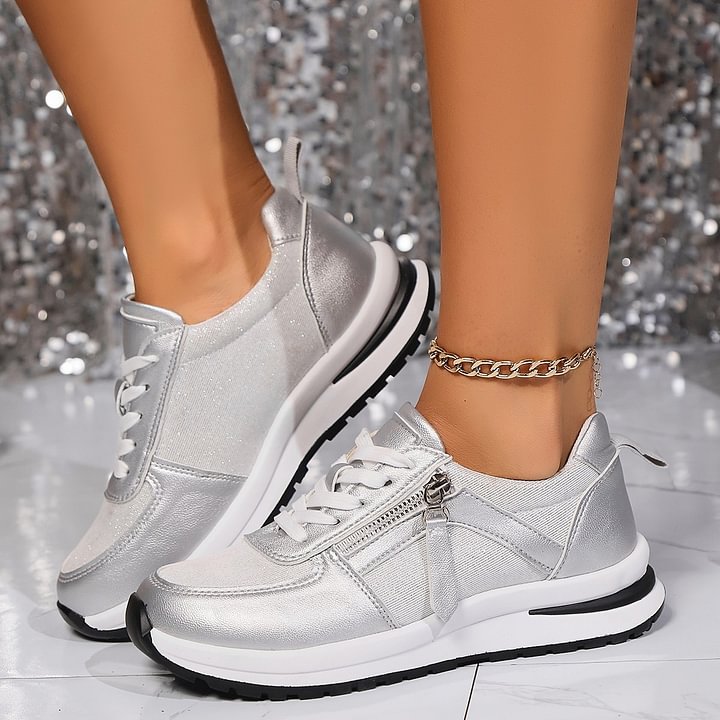 A woman in silver orthopaedic trainers with a handy side zip.
