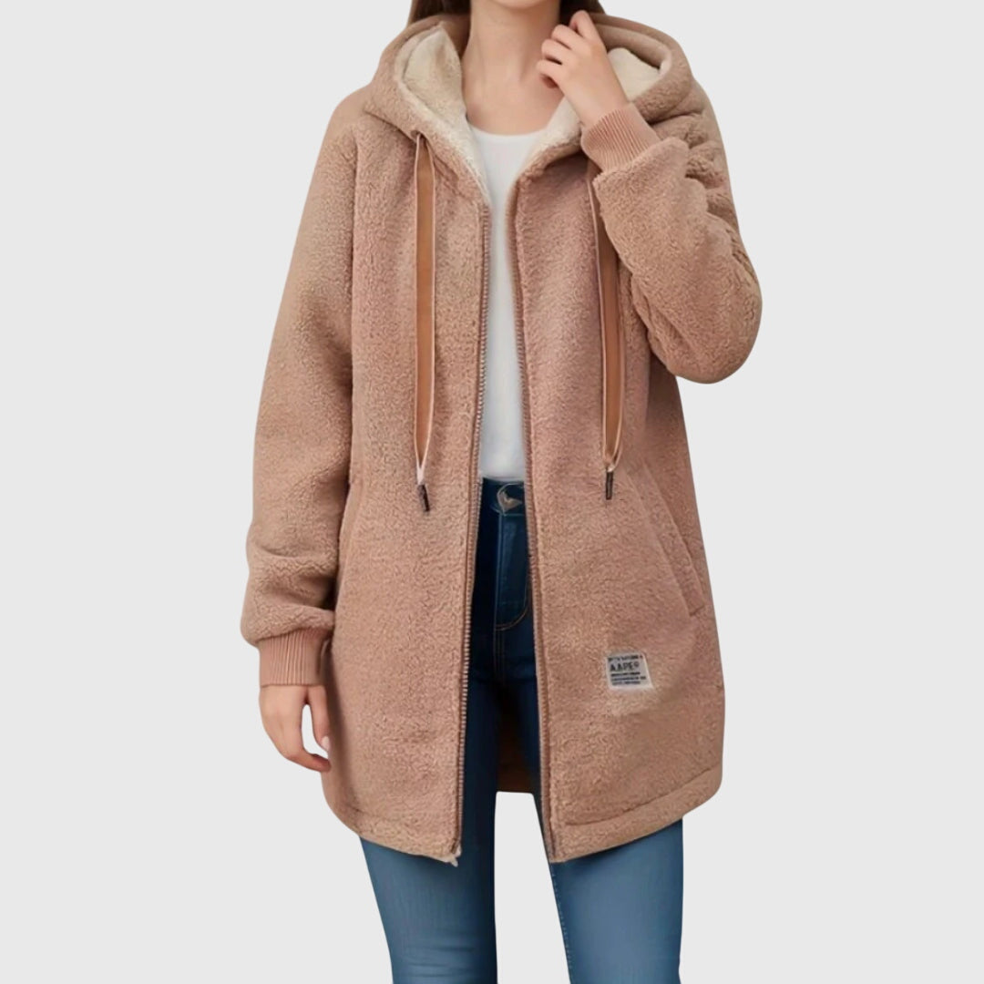 A woman wearing a cosy hooded jacket wrapped up warm on a cold winter morning.