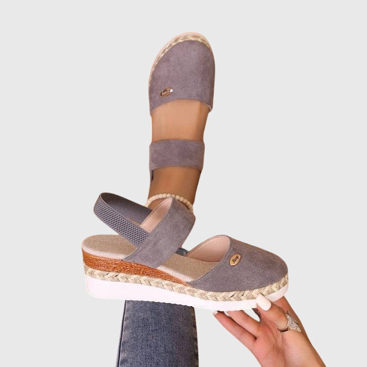 A woman walking comfortably in black cushioned support sandals with adjustable straps.