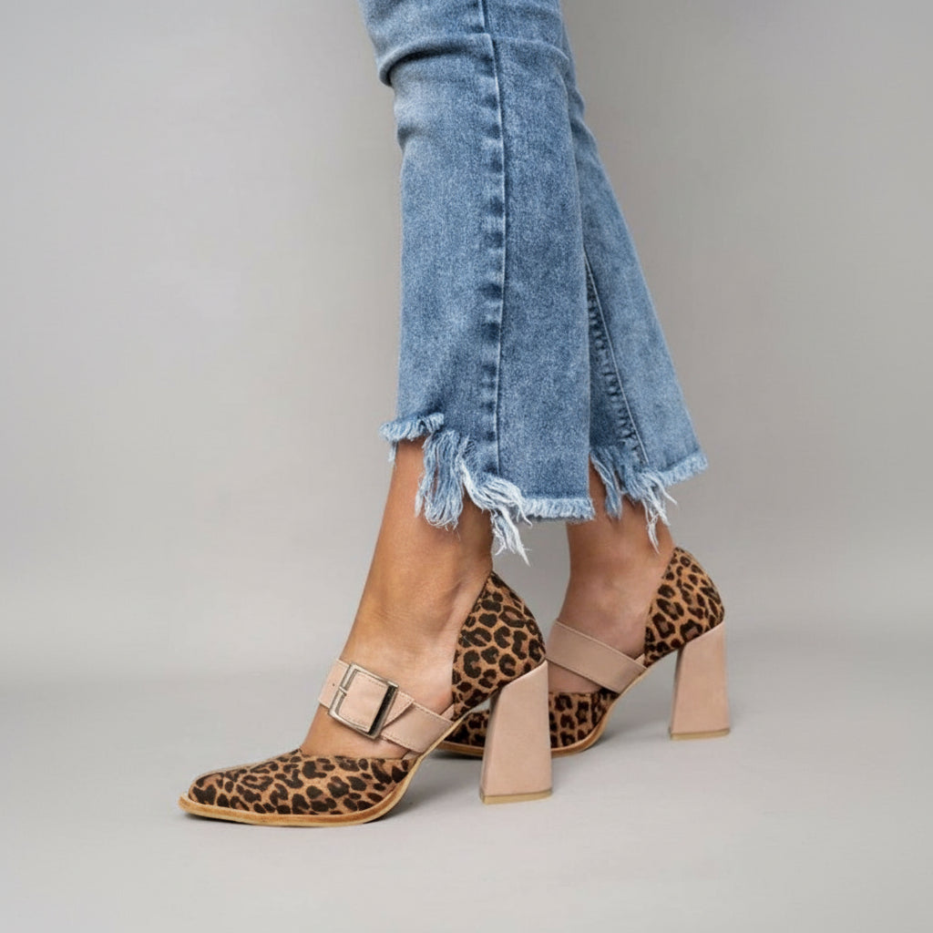 A woman wearing khaki pointed-toe high heels at a smart occasion.