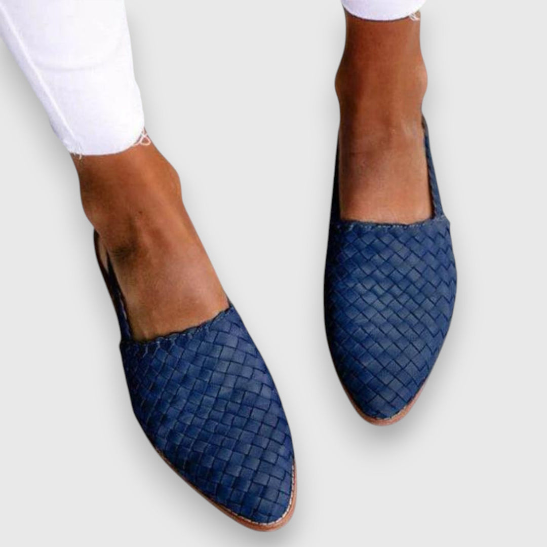 A woman wearing woven ballet flats with cropped jeans, looking relaxed and refined on a summer day.