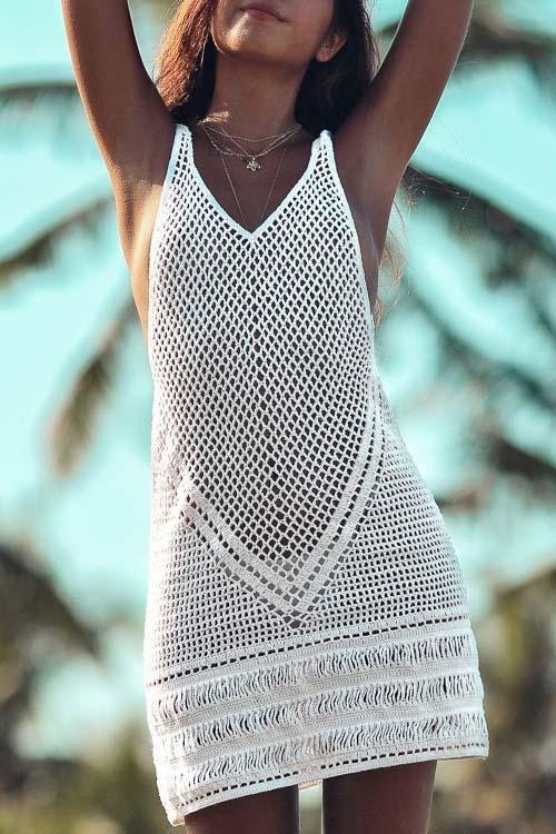 White boho beach dress with openwork crochet-style detailing worn as a swimwear cover-up