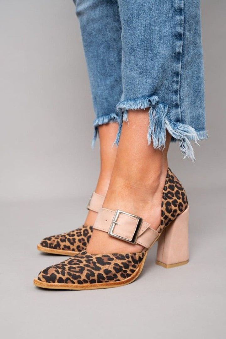 A woman wearing pointed khaki heels, stepping out in a polished day-to-evening outfit.