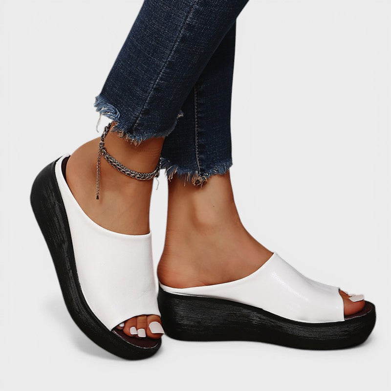 Open wedge mule sandals in white and brown with wide straps and a balanced wedge sole
