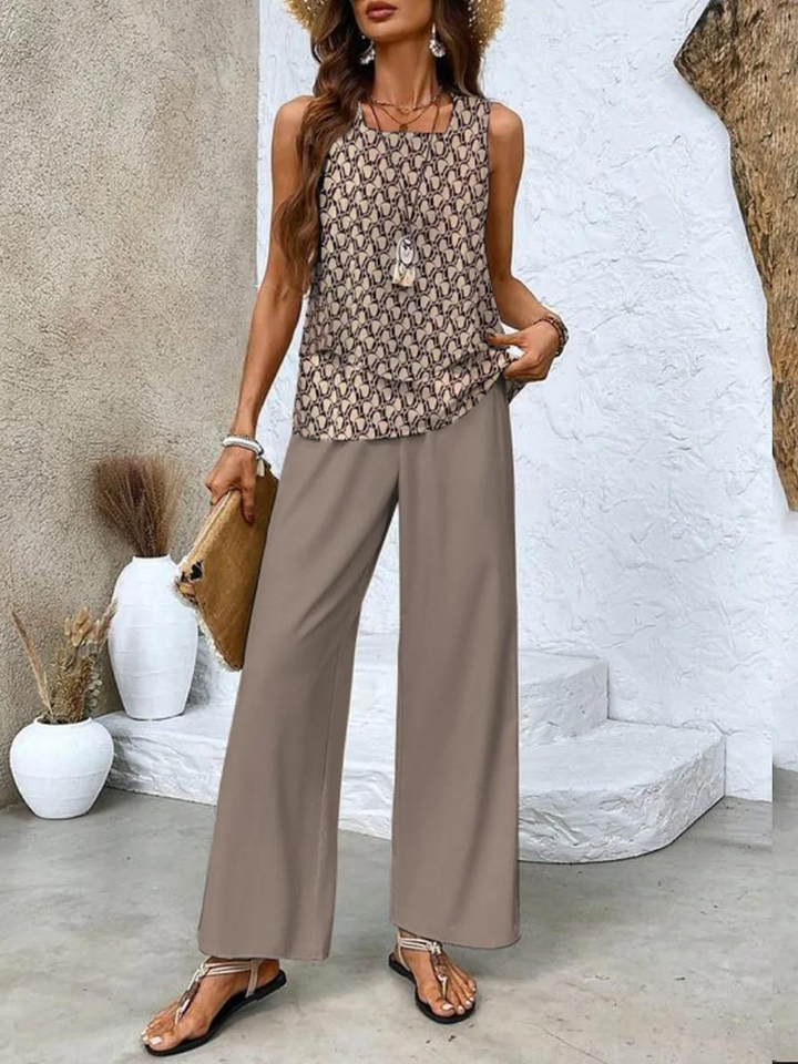 A woman wearing a layered sleeveless top with leaf-print wide-leg trousers, light and elegant.