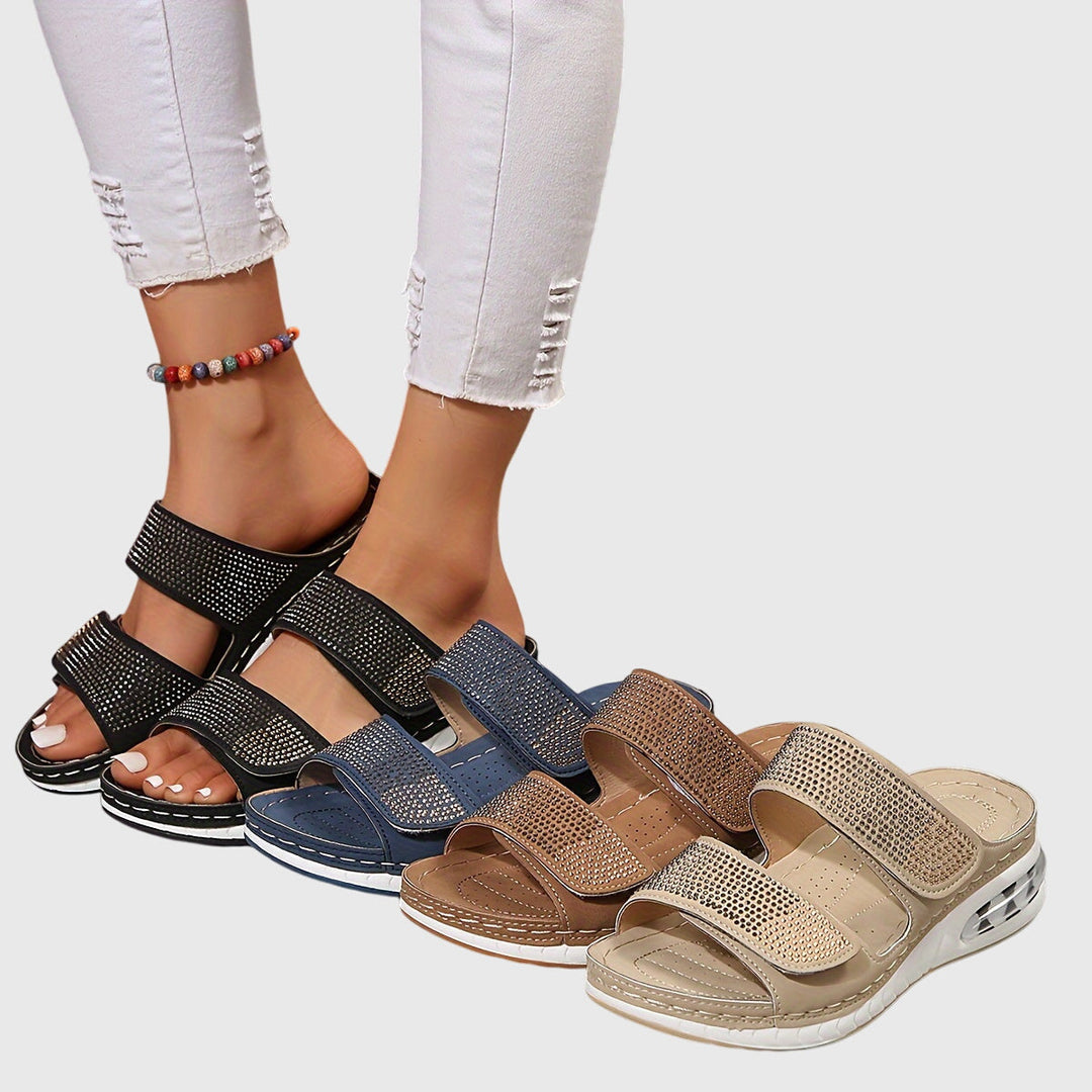 A woman standing confidently in cushioned arch-support sandals with a wide, roomy fit.