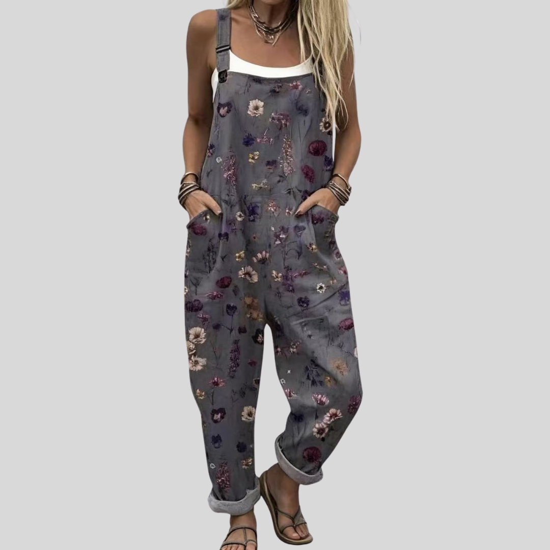 Woman wearing the Maeve™ dark charcoal harem-leg dungarees with an all-over ditsy print of small mauve, pink, and yellow flowers.