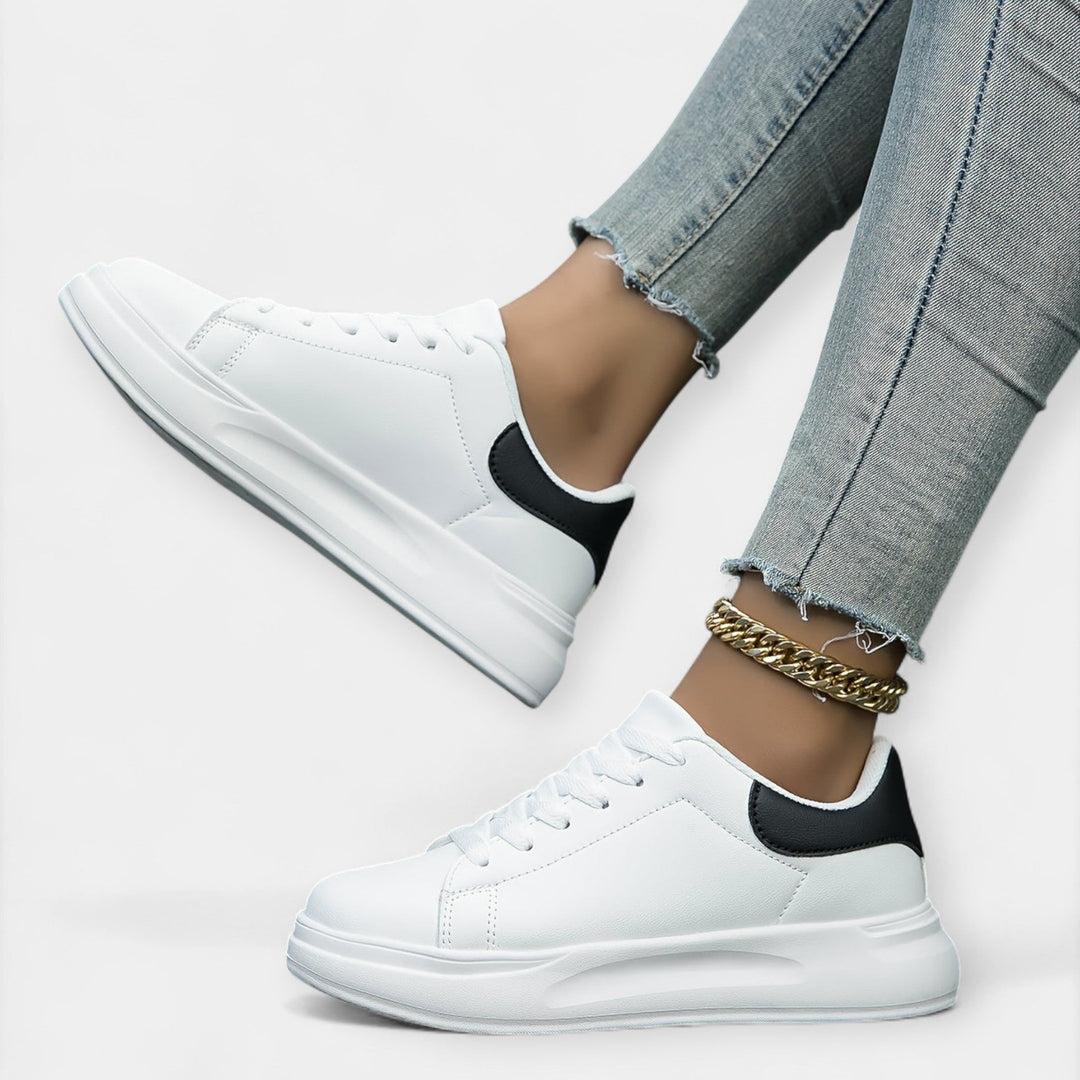 Women's classic white trainers with a clean minimal design and cushioned support sole