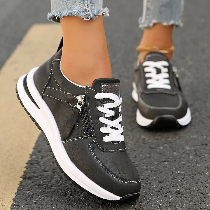 A woman wearing cushioned orthopaedic trainers with a side zip