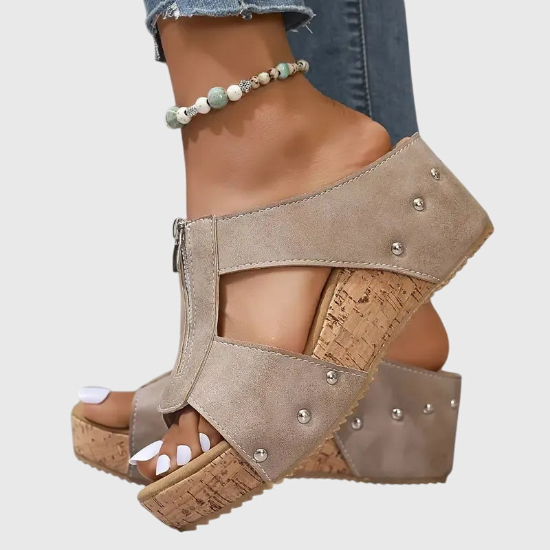 A woman standing comfortably in brown supportive sandals with an adjustable strap and cushioned sole.