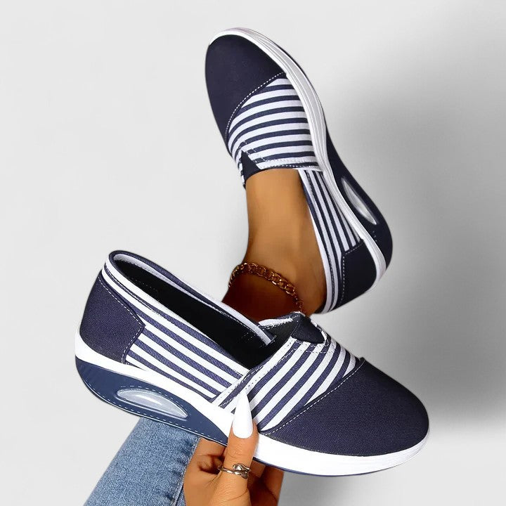 A woman wearing blue striped orthopaedic trainers on a walk